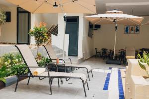 un groupe de chaises et de parasols sur une terrasse dans l'établissement Glands Ndera f04, à Kigali