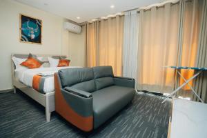 une chambre d'hôtel avec un lit et une chaise dans l'établissement Glands Ndera f04, à Kigali