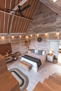 una camera da letto con un letto in una stanza con pareti in legno di Garden Terrace Bali a Gobleg