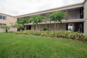 un edificio con palmeras frente a un patio en Motel 6-Miami, FL en Miami