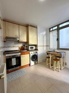 une cuisine avec une cuisinière et une table à l'intérieur dans l'établissement El Pasaje Apartamento, à Oviedo