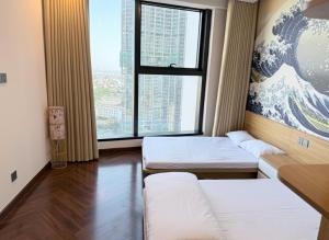 a room with two beds and a large window at QNC Taiyo Homestay in Hai Phong +23 photos
