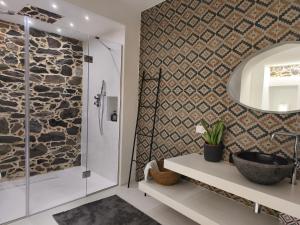 een badkamer met een inloopdouche naast een stenen muur bij Residenza Don Baddore in Dorgali