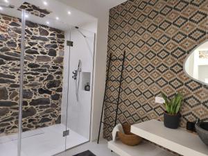 een badkamer met een douche en een stenen muur bij Residenza Don Baddore in Dorgali