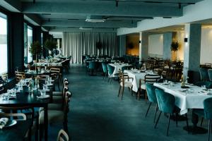 a dining room with tables and chairs with white tablecloths at Hotel Plein Air Residence & Resort in Vatra