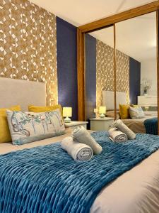 - un grand lit avec des serviettes dans l'établissement El Pasaje Apartamento, à Oviedo