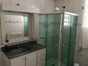 un bagno con doccia in vetro e lavandino di Carvalho Apê Centro I Poços de Caldas a Poços de Caldas Altre 10 foto