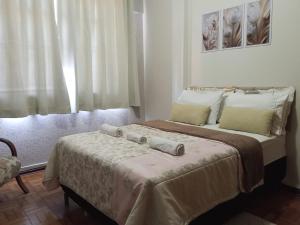 una camera da letto con un letto con due cuscini sopra di Carvalho Apê Centro I Poços de Caldas a Poços de Caldas