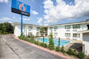 a hotel sign in front of a building with a pool at Motel 6-Dallas, TX - South in Dallas