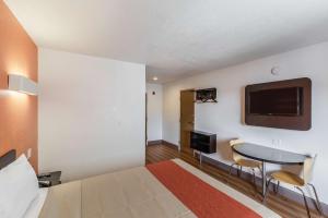 a hotel room with a bed and a table and a tv at Motel 6-Dallas, TX - South in Dallas