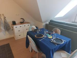 een tafel met een blauwe tafeldoek en een bank bij L'Eclose - Les Korrigans in Le Guilvinec