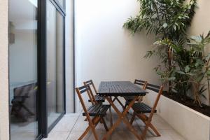 Ein Tisch und Stühle auf einem Balkon mit Pflanzen in der Unterkunft Nümad Suites in Nizza
