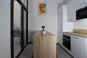 eine Küche mit einer hölzernen Kücheninsel, auf der eine Pflanze steht in der Unterkunft Nümad Suites in Nizza + 6 Fotos