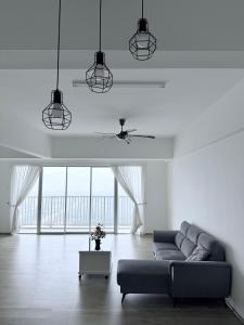 ein Wohnzimmer mit einer Couch und einem Deckenventilator in der Unterkunft The Ximplicity @ Venus Residence Sitiawan Manjung in Sitiawan