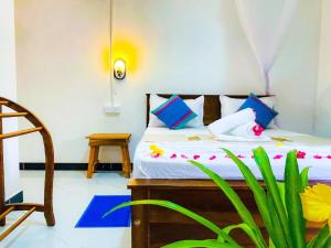 een slaapkamer met een bed met blauwe kussens en een plant bij Sigiri Rew Haven in Sigiriya +30 foto's