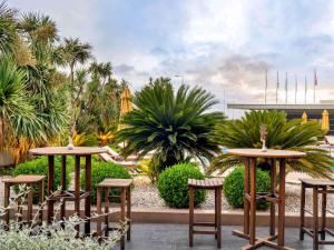 a patio with tables and chairs and palm trees at Ibis Istanbul Zeytinburnu in Istanbul