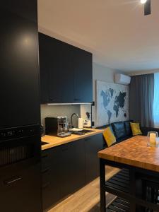 une cuisine avec des armoires noires et un salon dans l'établissement Apartament City Rent Płock, à Płock