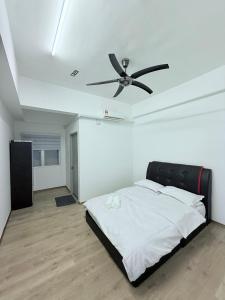 ein Schlafzimmer mit einem Bett mit Deckenventilator in der Unterkunft The Ximplicity @ Venus Residence Sitiawan Manjung in Sitiawan