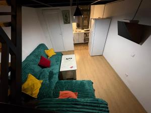 een woonkamer met een groene bank en kleurrijke kussens bij Old Tbilisi in Tbilisi City