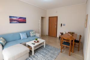 a living room with a blue couch and a table at DaMa Blue in Saronida