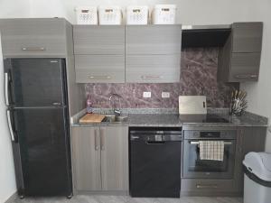 a kitchen with a black refrigerator and a sink at 2 Bedroom Duplex - Hurghada in Hurghada +9 photos