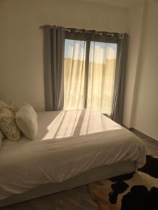 a bedroom with a white bed with a window at 2 Bedroom Duplex - Hurghada in Hurghada