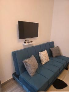 a blue couch in a living room with a flat screen tv at 2 Bedroom Duplex - Hurghada in Hurghada