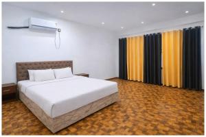 een slaapkamer met een groot wit bed en gordijnen bij Hotel Rajshree S- Gopal N Near Mathura Railway Station - Sri Krishna Janmabhoomi - Restaurant And Free Parking - Fully Air conditioning Luxuary Room - Best Hotel in Mathura