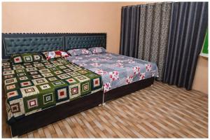 een slaapkamer met een bed met een dekbed erop bij Hotel Rajshree S- Gopal N Near Mathura Railway Station - Sri Krishna Janmabhoomi - Restaurant And Free Parking - Fully Air conditioning Luxuary Room - Best Hotel in Mathura