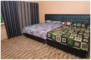 een slaapkamer met een bed met een dekbed erop bij Hotel Rajshree S- Gopal N Near Mathura Railway Station - Sri Krishna Janmabhoomi - Restaurant And Free Parking - Fully Air conditioning Luxuary Room - Best Hotel in Mathura