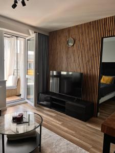 un salon avec une grande télévision et une table dans l'établissement Apartament City Rent Płock, à Płock 2 autres photos