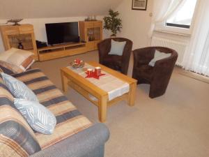 a living room with a couch and a table and chairs at Ferienwohnung Windten in Braunlage