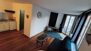 a living room with a couch and a tv at Harfleur Studio in Harfleur