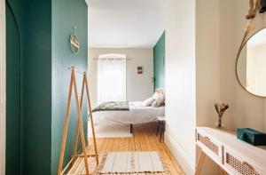 a room with a green wall and a mirror at L'Authentique Free parking in Mâcon