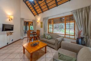 ein Wohnzimmer mit Sofa und Tisch in der Unterkunft Kruger Park Lodge Unit No. 543 in Hazyview