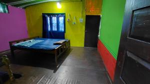 a room with a bed and a colorful wall at ABRU'S Holidays International Travelers in Alleppey