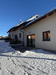 a house with snow in front of it at Apartmánové domy Lipno 1 in Frymburk