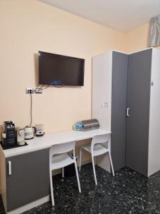 een bureau met een monitor aan de muur met een computer bij B&B Comfort Room 93 in Benevento