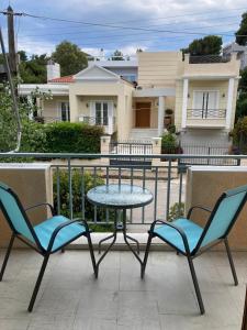 a patio with two chairs and a table and a table at DaMa Blue in Saronida