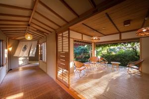 a room with a table and chairs on a wooden floor at 御宿竹林亭 in Takeo