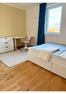 a bedroom with a bed and a desk and a window at Atelier K7 in Žilina
