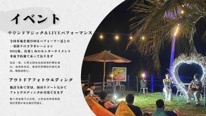 MatsuuraGlamping village Seagrand的一群人晚上坐在舞台上