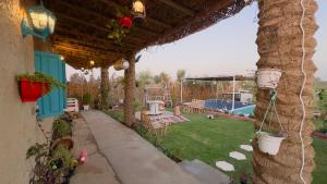 a house with a patio and a yard with a yard at Byet ahalna in Mūsá
