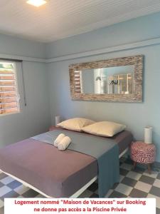 een slaapkamer met een bed en een spiegel aan de muur bij Dez'îles Guadeloupe in Sainte-Anne