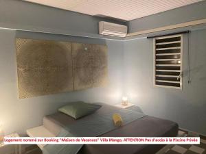 a bedroom with a bed and a window at Dez'îles Guadeloupe in Sainte-Anne