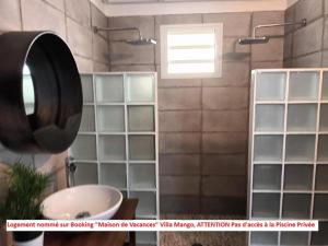 een badkamer met een wastafel en een spiegel bij Dez'îles Guadeloupe in Sainte-Anne