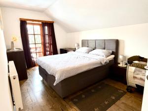 een slaapkamer met een groot bed en een raam bij Gorski kotar , Kuća za odmor Kratohvil in Lukovdol +48 foto's