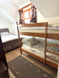 een kamer met 2 stapelbedden en een bank bij Gorski kotar , Kuća za odmor Kratohvil in Lukovdol