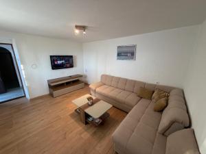 a living room with a couch and a tv at Vacation home TEA in Senj