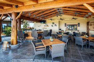 een restaurant met houten plafonds en tafels en stoelen bij Oceanfront Condo Halii Kai 14D in Waikoloa